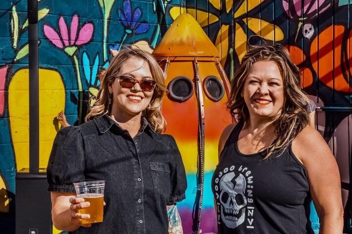 Janel Raihl, Alison Wainwright, pose in front of garden mural artwork at Voodoo Brewery Las Vegas.